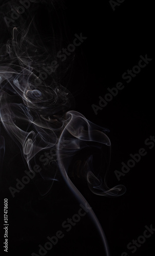 Abstract cloud of white smoke swirling on black background