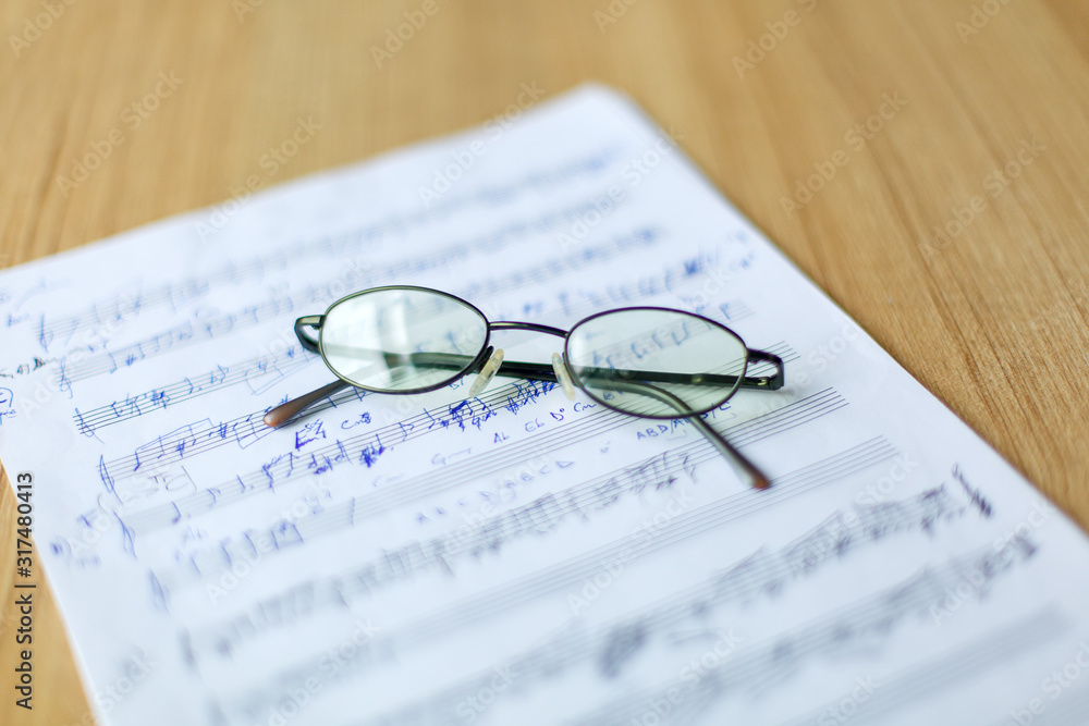 musical manuscript with notes, glasses in the background musical manuscript with notes, glasses in the background