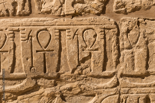 Karnak Temple, complex of Amun-Re. Embossed hieroglyphics on walls. Luxor Governorate, Egypt. Ankh is an ancient Egyptian hieroglyphic symbol that means the word "life".