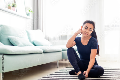 Young asian girl resting after training at home in living room