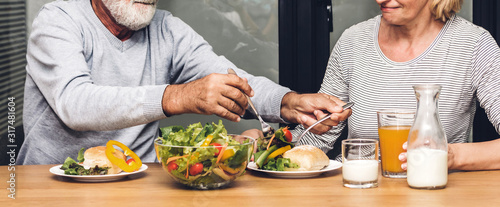 Slika na platnu Senior couple enjoy eating  healthy breakfast together in the kitchen