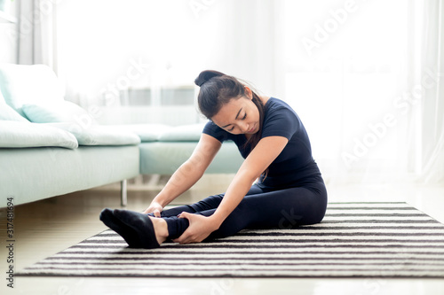 Young asian girl training at home on carpet in living room