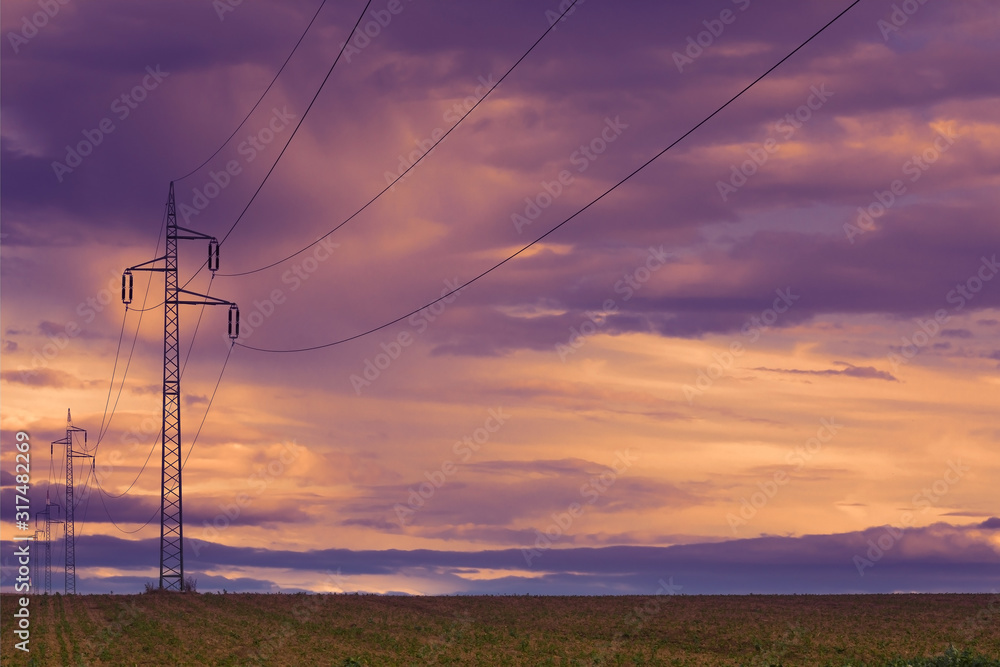 Power line and field at sunset sky. Autumn landscape.