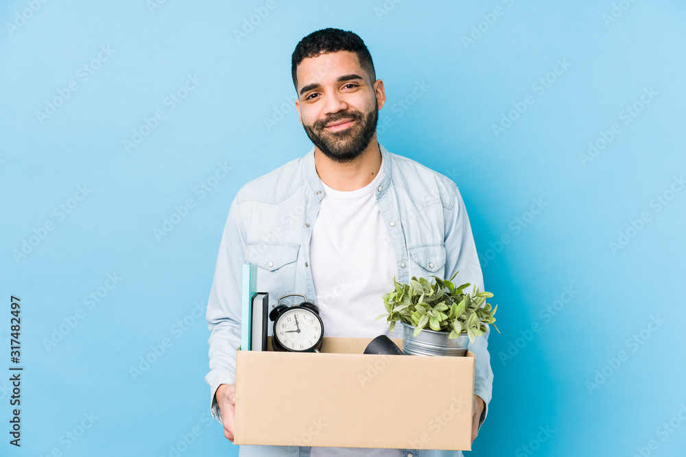 Young arabian man moving to a new home isolated happy, smiling and cheerful. Young arabian man moving to a new home isolated happy, smiling and cheerful.