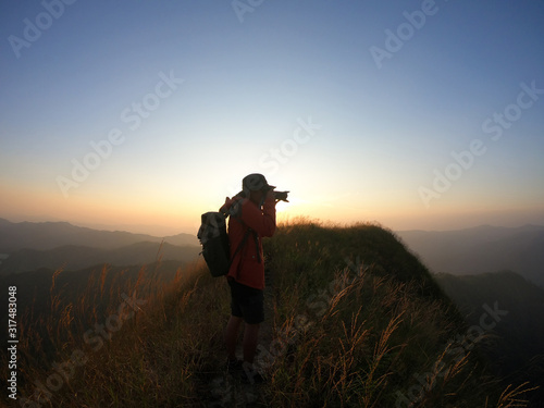 Male photographer taking photo on mountain at sunset ©  Berlin23