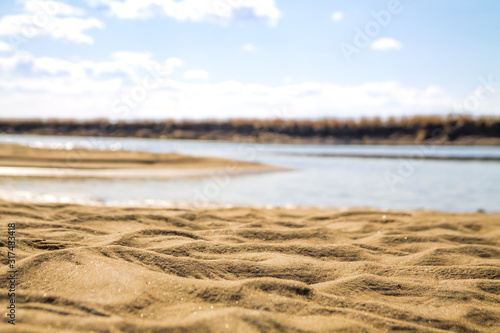 river bank with sand dunes with defocused shallow waters of river on the background