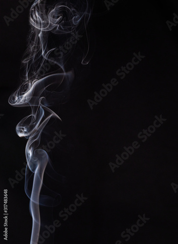 Abstract cloud of white smoke swirling on black background