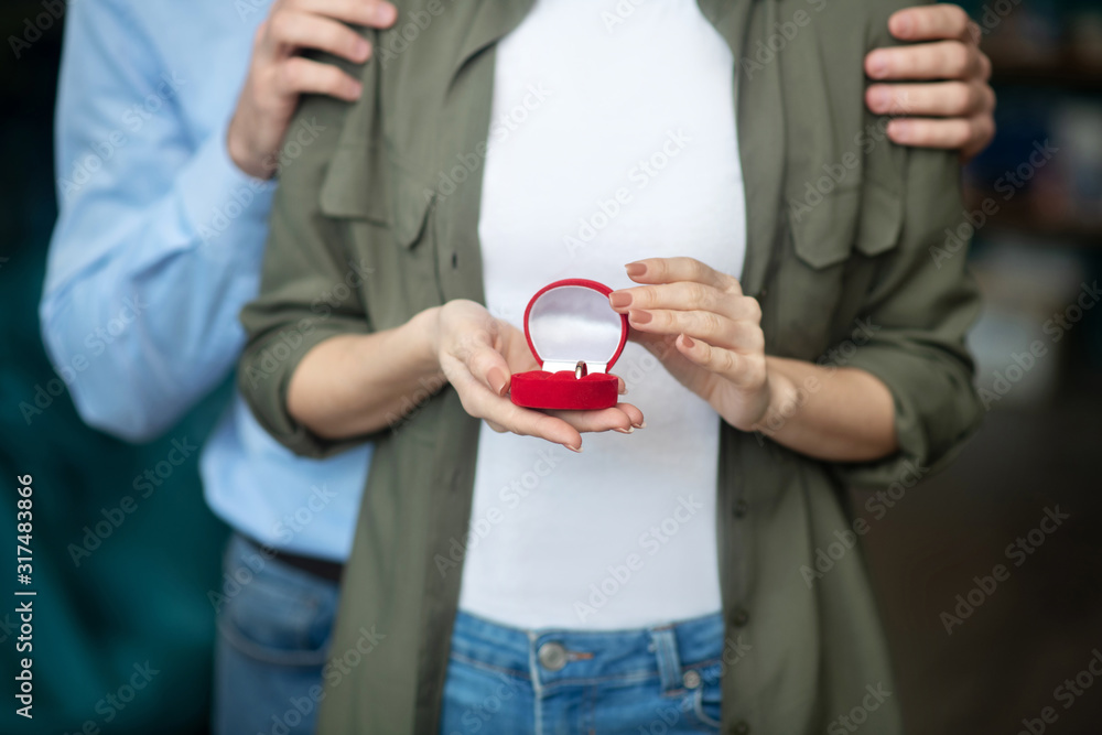 Man and a woman holding an engagement ring box