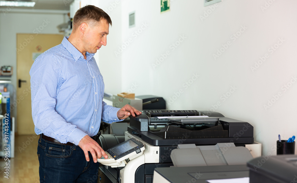 Obraz premium Confident businessman using printer in office