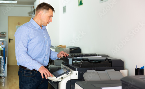 Confident businessman using printer in office