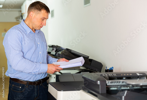 Businessman working with printer in the office