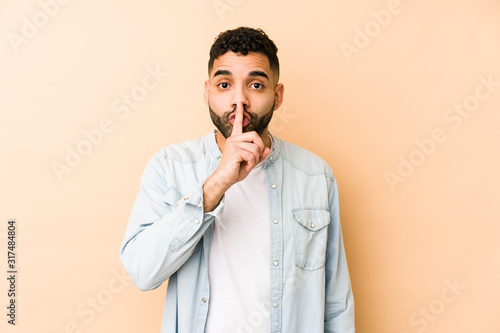 Young mixed race arabic man isolated keeping a secret or asking for silence.