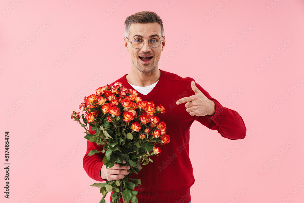 Portrait of handsome man wearing eyeglasses pointing finger at flowers Portrait of handsome man wearing eyeglasses pointing finger at flowers