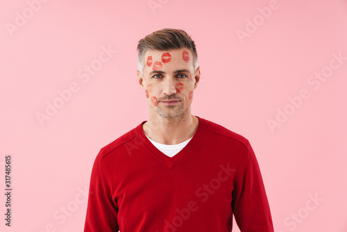 Portrait of handsome man with kiss marks at his face on valentines day