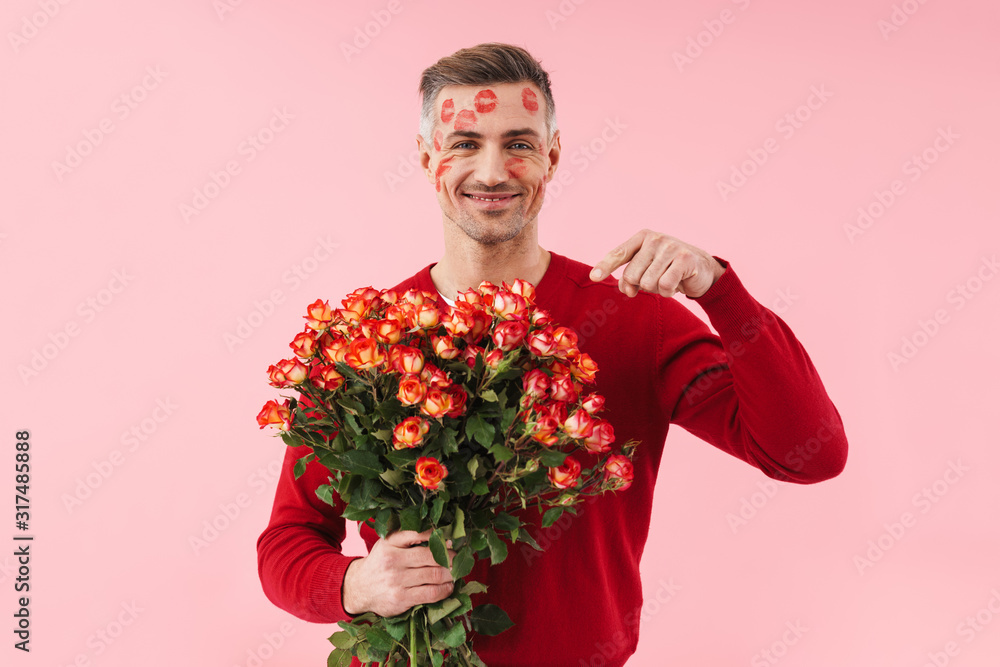 Portrait of man with kiss marks holding flowers on valentines day Portrait of man with kiss marks holding flowers on valentines day