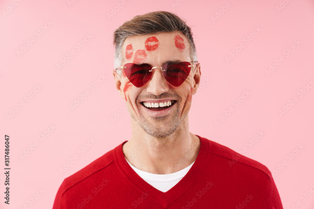 Obraz premium Portrait of man with kiss marks at his wearing heart-shaped sunglasses