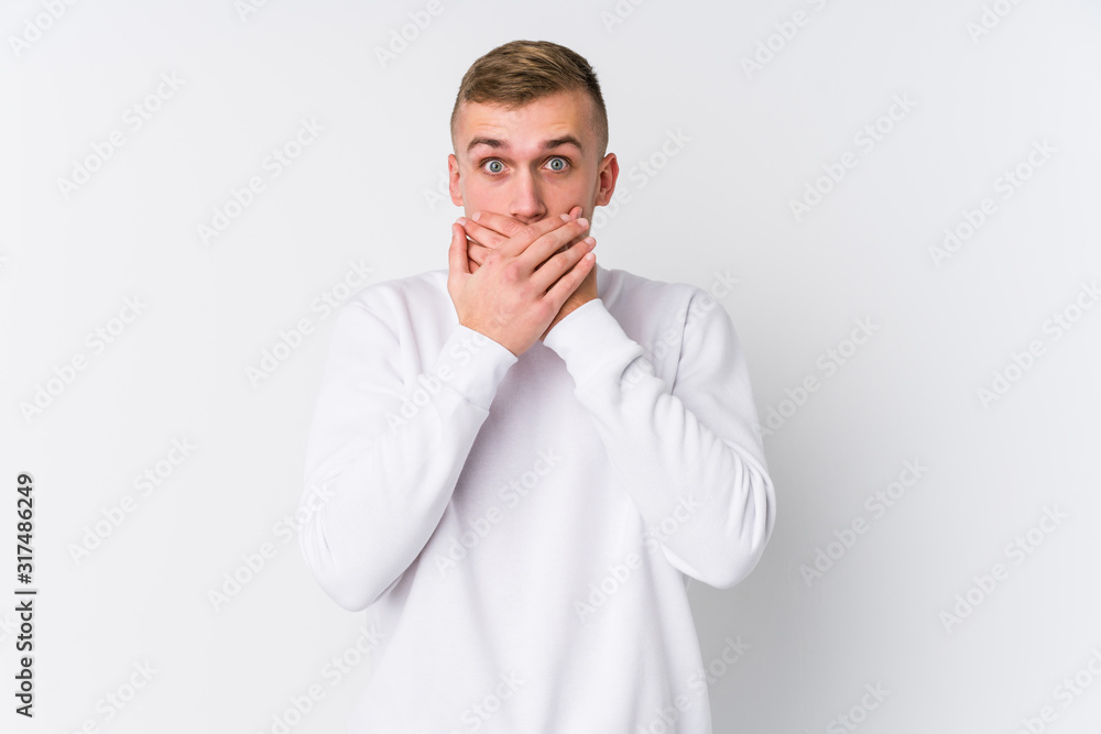 Young caucasian man on white background shocked covering mouth with hands. Young caucasian man on white background shocked covering mouth with hands.