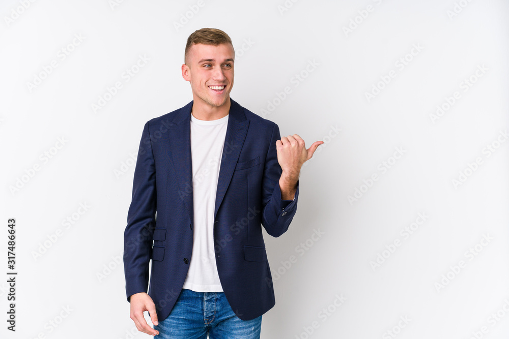 Young business caucasian man points with thumb finger away, laughing and carefree. Young business caucasian man points with thumb finger away, laughing and carefree.