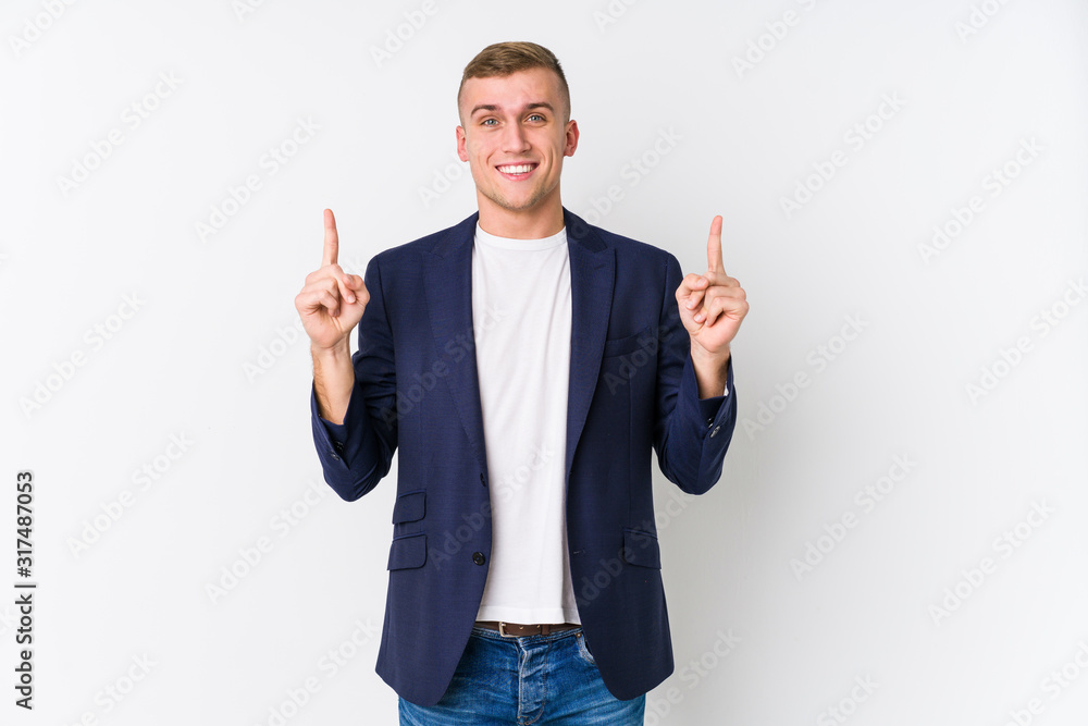 Young business caucasian man indicates with both fore fingers up showing a blank space. Young business caucasian man indicates with both fore fingers up showing a blank space.