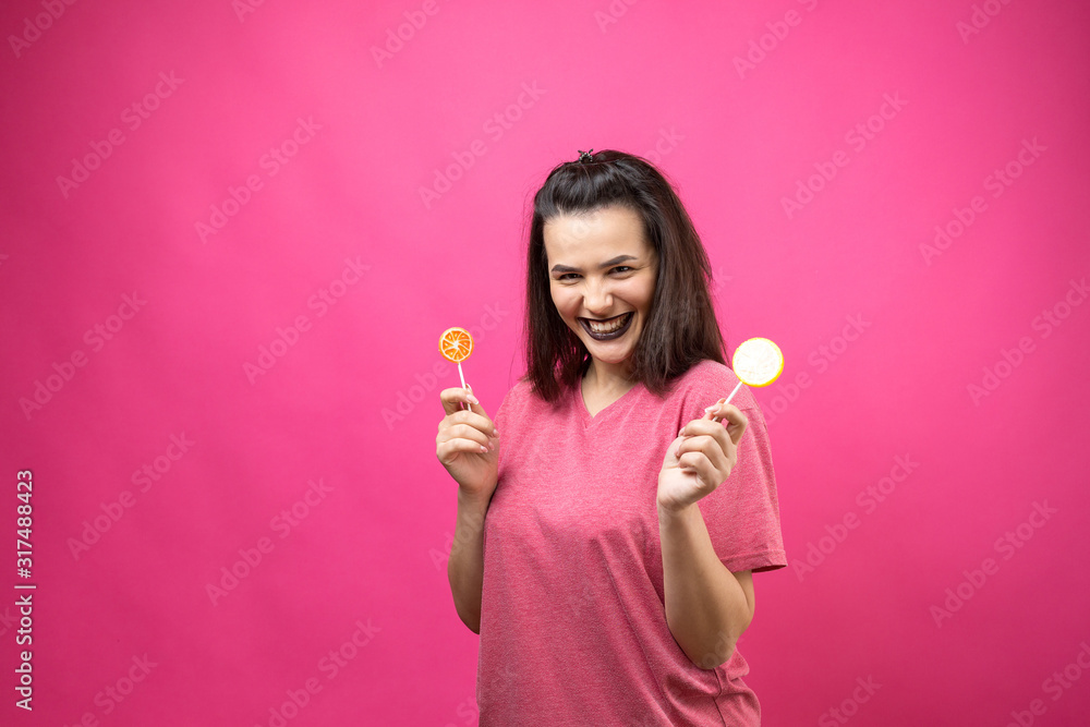 Portrait of lovely sweet beautiful cheerful woman with straight brown hair holding a lollipop near the eyes. Portrait of lovely sweet beautiful cheerful woman with straight brown hair holding a lollipop near the eyes.