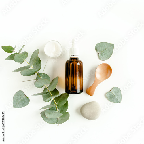 Bottle of eucalyptus essential oil  eucalyptus leaves on white background. Natural   Organic cosmetics products. Flat lay  top view.