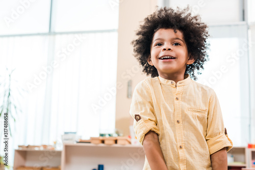 Low angle view of african american kid smiling while looking away