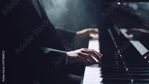 Man two hands plays gentle classical music on a grand piano. Professional pianist photo