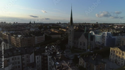 Aerial view of Östermalm district at sunset. Oscar's Church (Oscarskyrkan), apartment buildings and street. Drone shot flying over rooftops of Stockholm. Capital city of Sweden, cityscape skyline photo