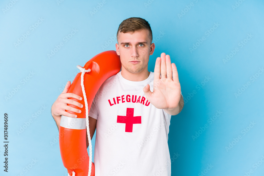 Young lifeguard man holding a rescue float standing with outstretched ...