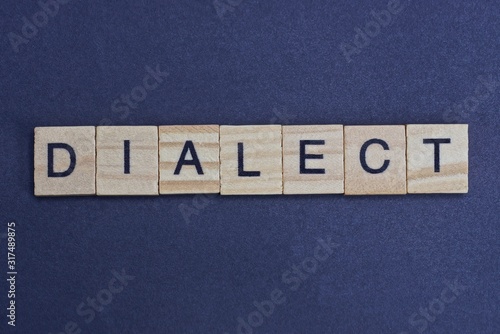 gray word dialect from small wooden letters on a black table photo