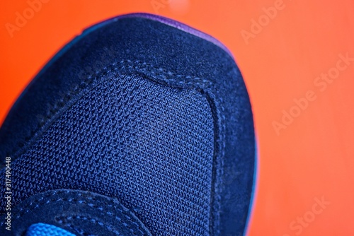 part of one blue sneaker on a red background