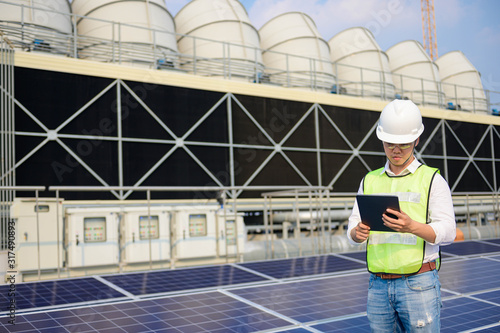 Engineer check condition  Solar cell roof top and cooling tower project at industry solar power, Renewable energy Concept.