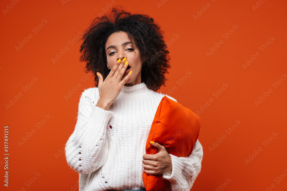 Tired young african woman hugging a pillow Tired young african woman hugging a pillow
