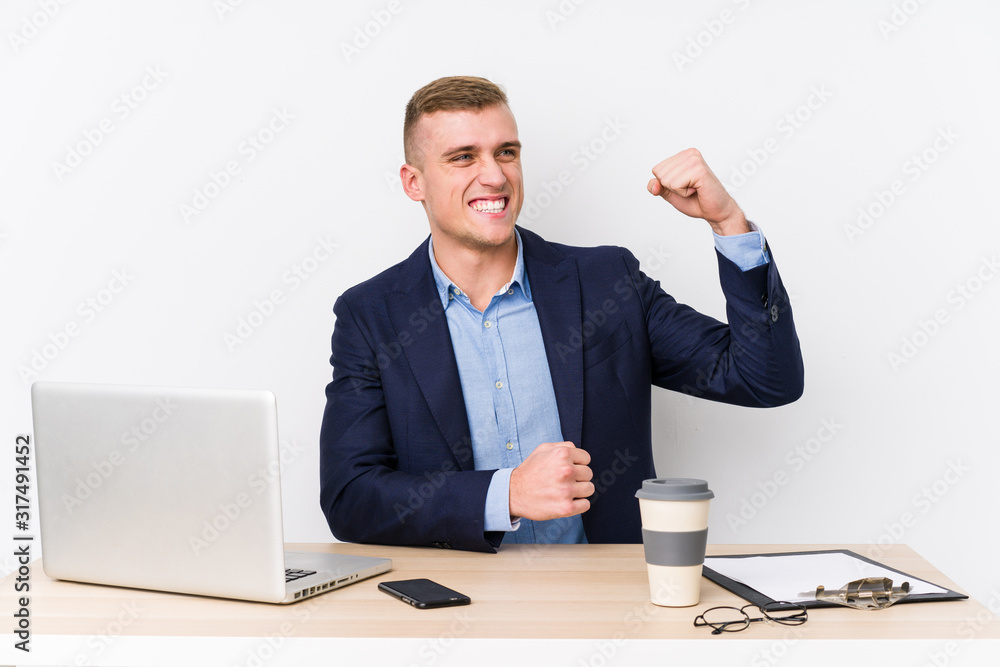 Young business man with a laptop raising fist after a victory, winner concept. Young business man with a laptop raising fist after a victory, winner concept.