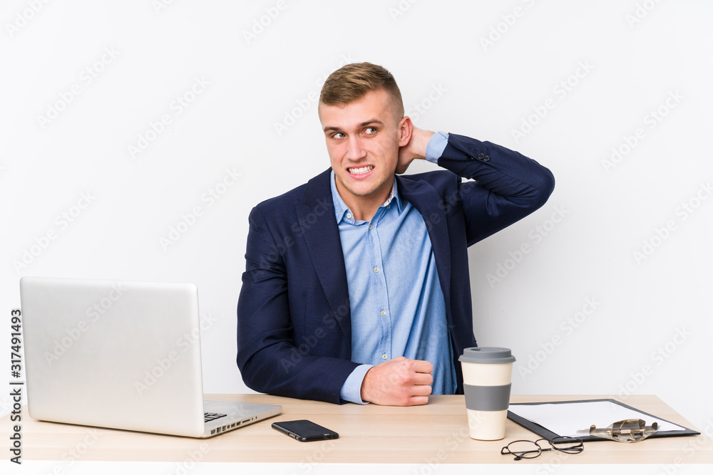 Young business man with a laptop touching back of head, thinking and making a choice. Young business man with a laptop touching back of head, thinking and making a choice.