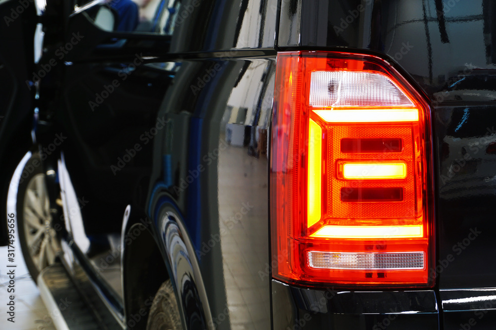 Close-up taillight of a modern luxury car. Electrical equipment and light of a modern car. Quality spare parts concept. Service and car repair concept.