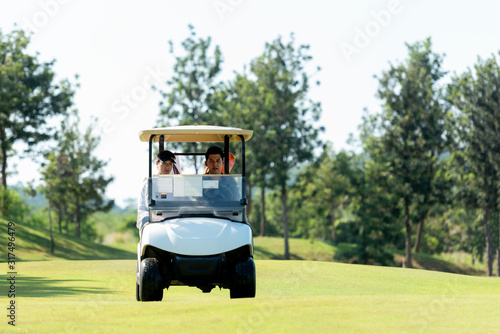 Golfer sport course golf ball on green grassÂ  People lifestyle man and friend siting on car golf in fairway.Â  Asian man player game shot in summer.Â  Healthy and Sport outdoor