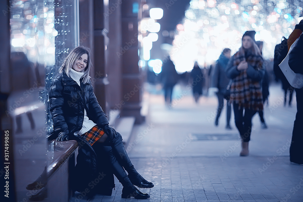 Obraz premium Christmas shopping girl city, young model evening gift shopping, seasonal sale, winter evening outside in the city