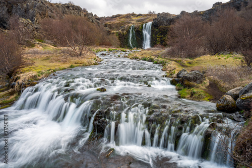 Waterfall cascade in the area of Gjain in Porsdalur in the Icelandic highlands. Overcast sky. Long exposure shot of the river. Travling concept.