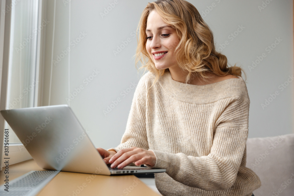 Naklejka premium Optimistic young woman using laptop computer.