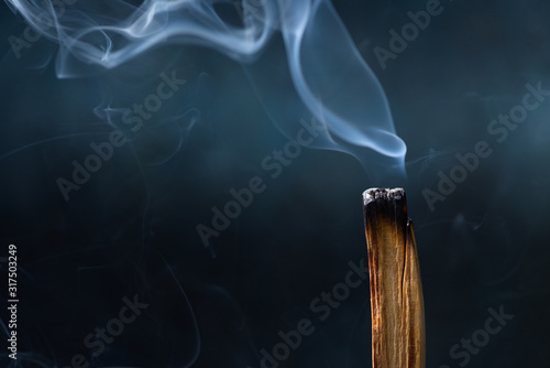 Palo Santo, Bursera graveolens, holy sacred tree stick, burning with beautiful aromatic smoke photo
