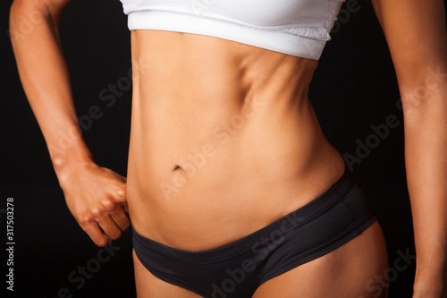 Flat and strong core - female abdominal on black background © Hope