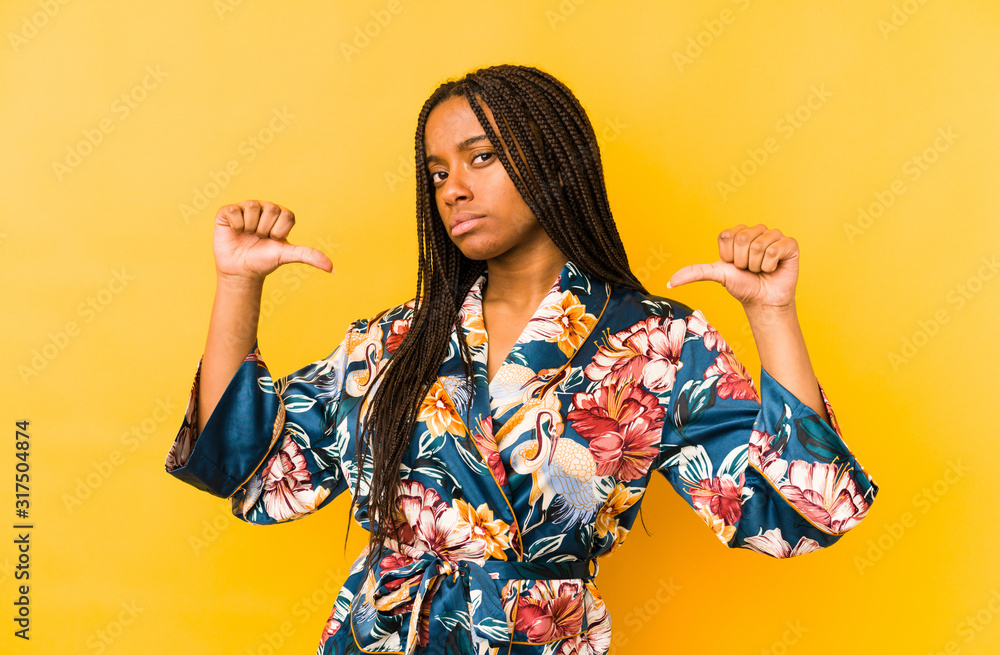 Young african american woman wearing an asiatic pijama isolated feels proud and self confident, example to follow. Young african american woman wearing an asiatic pijama isolated feels proud and self confident, example to follow.