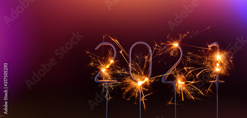 Happy New Year 2021 banner template. Digits of year 2021 made by burning sparklers isolated on black background.