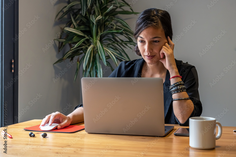 Young woman working online at home with laptop and documents Young woman working online at home with laptop and documents