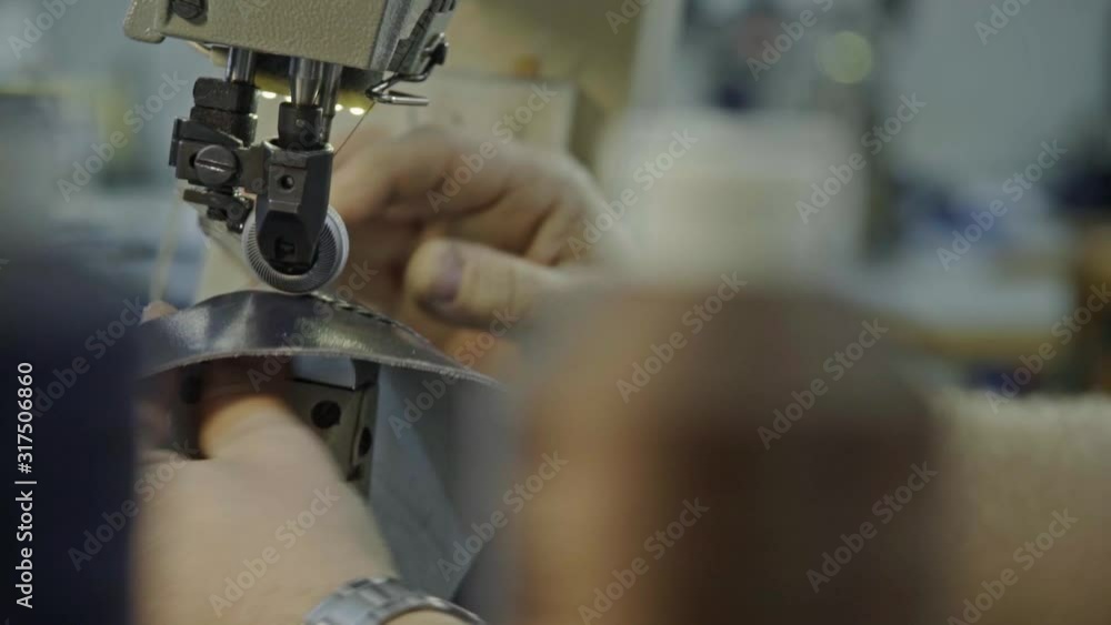 Craftsman preparing details of a future shoe, stitching small details with bigger ones, on industrial sewing mashine for shoe making. Craftsman preparing details of a future shoe, stitching small details with bigger ones, on industrial sewing mashine for shoe making.