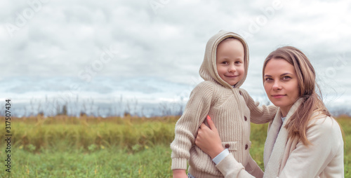 Woman mother child  little son boy 4-5 years old  autumn park  hugging  emotions of happiness  pleasure  casual warm clothes with hood. Parenting and caring for children. Free space copy text.