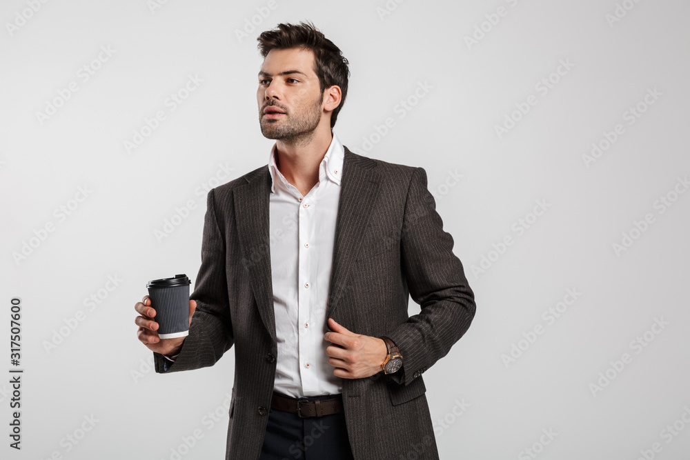 Image of young successful businessman drinking coffee takeaway Image of young successful businessman drinking coffee takeaway