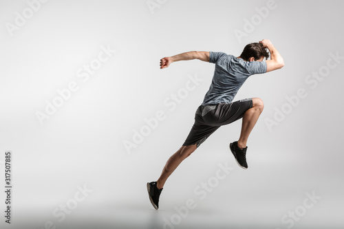 Image of young athletic man doing exercise while working out