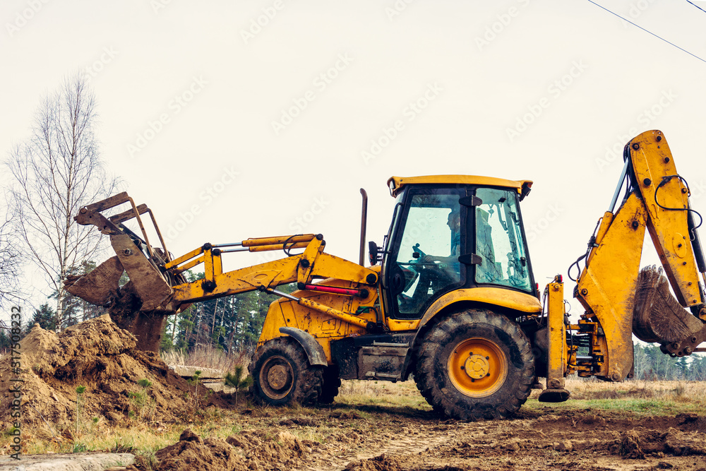The excavator in the countryside moves the concrete slabs for the road. The excavator in the countryside moves the concrete slabs for the road.